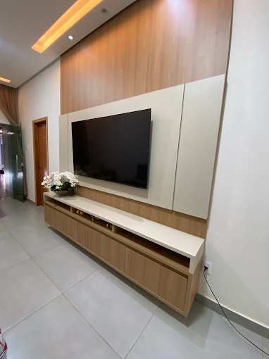 Painel de TV em madeira com rack suspenso e iluminação embutida no forro